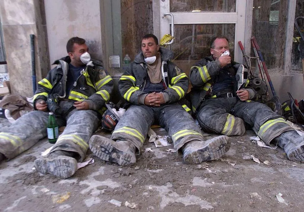 Exhausted firefighters rested on Broadway.