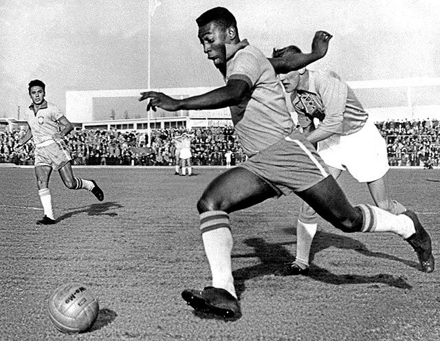 Pelé dribbling past a defender while playing for Brazil, May 1960