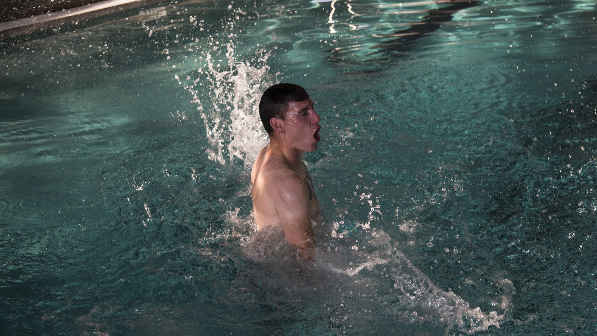 JOINT BASE CHARLESTON, S.C. - U.S. Navy Machinist Mate 2nd Class Andrew Kessler, Harbor Patrol Unit, performs the burning oil maneuver during the first-class swim qualification test