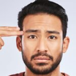 Man pointing fingers at his head like a gun