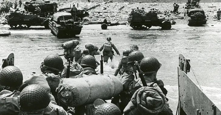American troops landing at Omaha Beach, June 6, 1944. The presence of tracked vehicles and DUKWs (“Ducks”) on the beach and the organized columns of men heading inland indicate that this photo was taken several hours after the initial infantry assault.